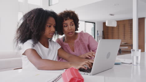 Mujer-Negra-De-Mediana-Edad-Ayudando-A-Su-Hija-Adolescente,-Usando-Una-Computadora-Portátil-A-Hacer-Su-Tarea,-De-Cerca