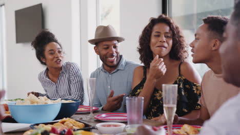 Drei-Generationen-Schwarze-Familie,-Die-Zusammen-Am-Esstisch-Sitzt-Und-Während-Einer-Familienfeier-Spricht