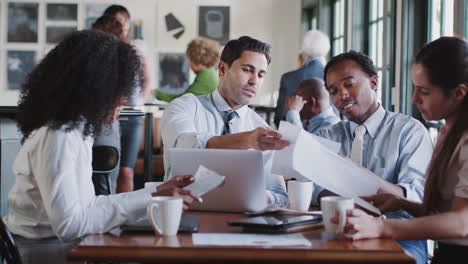 Business-Team-Having-Informal-Meeting-Around-Table-In-Coffee-Shop