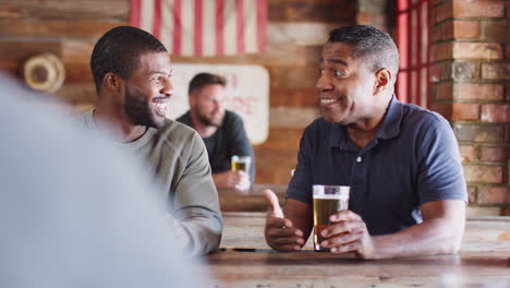 Two-Male-Friends-Meeting-In-Sports-Bar-Enjoying-Drink-Before-Game
