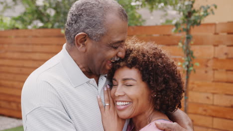 Senior-black-man-and-his-middle-aged-daughter-laughing-and-embracing-outdoors,-close-up