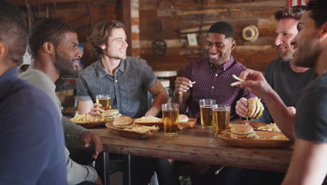 Male-Friends-Drinking-Beer-And-Eating-Burgers-In-Sports-Bar