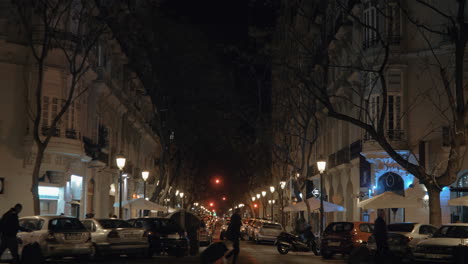Night-street-lined-with-trees-lanterns-and-parked-cars-Valencia-Spain