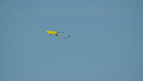 A-bright-yellow-kite-flying-in-clear-sky