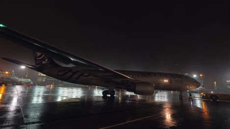 Flugzeugrückstoß-Am-Flughafenblick-In-Regnerischer-Nacht