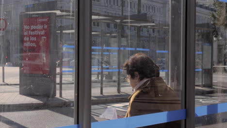 Senior-woman-at-bus-stop-in-Madrid-Spain
