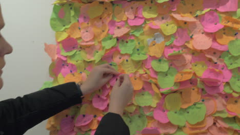 Woman-pinning-a-piece-of-paper-with-heart-onto-the-wish-board