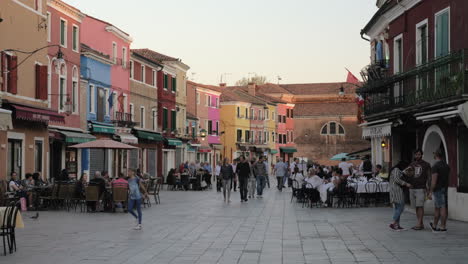 Lively-street-in-Burano-with-people-in-outdoor-cafes-Italy