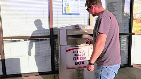 Man-Votes-in-Election-by-Dropping-Mail-in-Ballot-Letter-in-Slot-at-Voting-Booth-with-Offical-Ballot-Drop-Box-Sign-for-Democratic-Government-Campaign-in-Presidential-Race