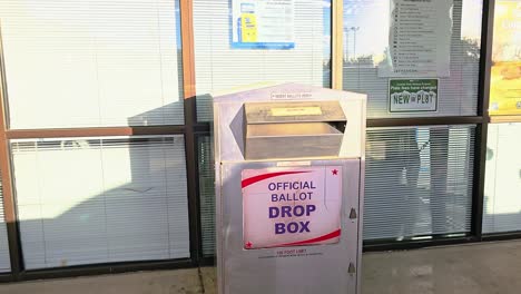 Millennial-Woman-Votes-by-Droping-Mail-in-Ballot-Letter-in-Slot-at-Voting-Booth-with-Offical-Ballot-Drop-Box-Sign-for-Democratic-Government-Election-in-Presidential-Race
