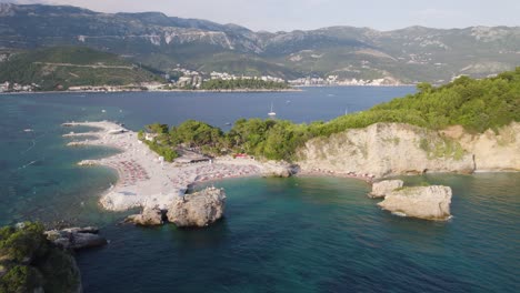 Quaint-crescent-moon-bay-beaches-in-Budva-Sveti-Nikola-Island-in-Montenegro,-aerial