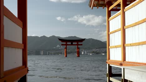 Calm-And-Contemplative-View-Between-Two-Buildings-Of-Jinja-Otorii-Floating-In-Water-At-Itsukushima,-Japan