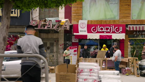 Punto-De-Vista-De-Un-Automóvil-Conduciendo-Por-La-Calle-A-Lo-Largo-De-Las-Tiendas-Y-El-Mercado-En-Hebrón,-Palestina