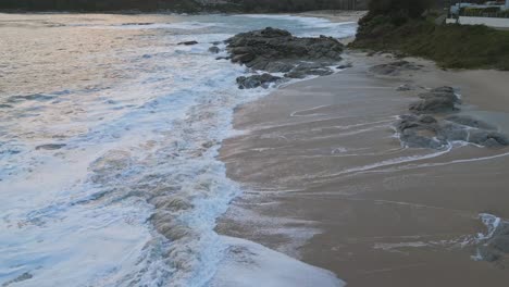 White-sand-beach-with-breaking-waves-at-the-rocks