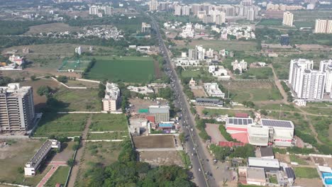 Rajkot-city-aerial-view-Drone-camera-is-moving-over-Kalavad-road,-and-traffic-is-visible-on-the-road