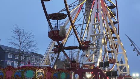 Ferris-wheel-slowly-turning-with-night-falling-in-Cork-city,-Ireland