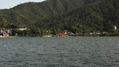 Blick-Auf-Den-Schwimmenden-Shinto-Schrein-Von-Itsukushima-In-Der-Ferne-Vom-Vorbeifahrenden-Boot-Aus
