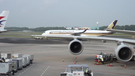 Ein-Schlepper-Zieht-Ein-A350-Flugzeug-Der-Singapore-Airlines-über-Die-Landebahn-Des-Flughafens-Changi