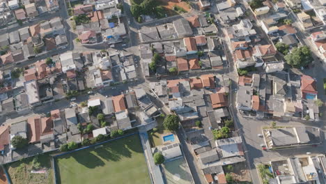 Slow-aerial-flyover-of-a-soccer-field-and-neighborhoods-in-Brasilia,-Brazil