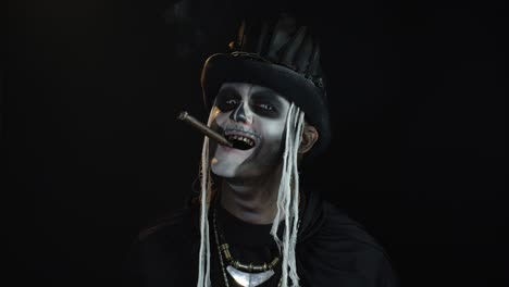 Frightening-man-in-skeleton-Halloween-cosplay-costume-smoking-cigar,-making-faces,-smiling
