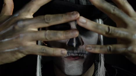 Man-in-skeleton-Halloween-cosplay-costume.-Guy-in-creepy-skull-makeup-looking-wide-open-eyes