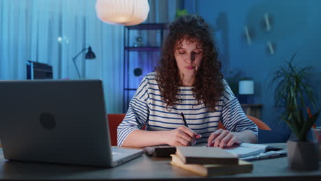 Young-business-woman-working-with-laptop-computer-and-documents-planning-expenses-budget-at-home