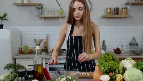 Vegan-woman-looking-for-culinary-recipe-online-on-mobile-phone.-Cooking-salad-with-raw-vegetables