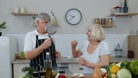 Ältere-Frau-Und-Mann-Machen-Einen-Lustigen-Tanz-Mit-Sieben.-Tanzen-Beim-Gemeinsamen-Kochen-In-Der-Küche