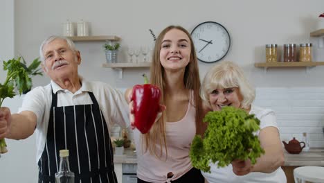 Grandchild-girl-with-senior-grandparents-recommending-eating-raw-vegetable-food.-Nutrition-diet