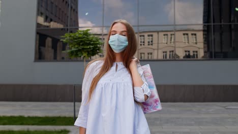 Teenager-girl-with-multicolor-shopping-bags-wearing-protect-mask.-Black-Friday-during-coronavirus