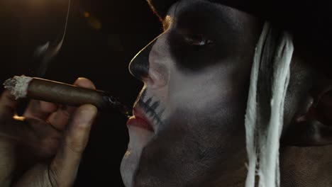 Frightening-man-in-skeleton-Halloween-cosplay-costume-smoking-cigar,-making-faces,-showing-tongue