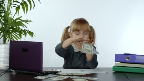 Young-child-girl-boss-holds-a-lot-of-money,-rejoices-in-the-win-and-makes-money-rain-scatters-money