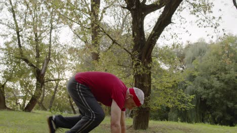 Active-senior-old-man-do-push-ups-physical-exercises-in-park.-Grandfather-training-fitness-workout