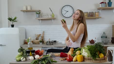 Girl-recommending-eating-raw-vegetable-food.-Showing-avocado-in-hands.-Weight-loss-and-diet-concept