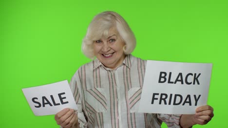 Senior-grandmother-showing-Sale-word-and-Black-Friday-inscription-advertisement-banners.-Discounts