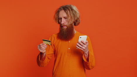 Mann-Nutzt-Smartphone-Mit-Kreditkarte,-Während-Er-Taschengeldkäufe-Beim-Online-Shopping-überweist