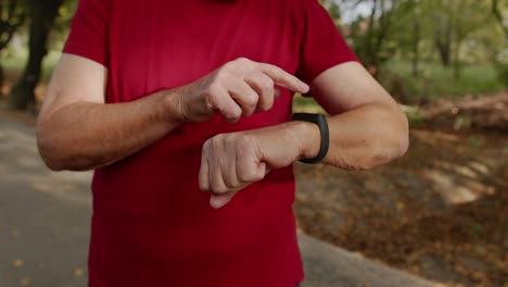 Älterer-Alter-Läufer-Beginnt,-Auf-Den-Touchscreen-Seiner-Smartwatch-Zu-Tippen,-Die-Entfernung-Zu-Verfolgen-Und-Den-Puls-Zu-überprüfen