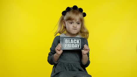Cheerful-stylish-child-girl-smiling,-holding-Black-Friday-text-inscription,-rejoicing-good-discounts
