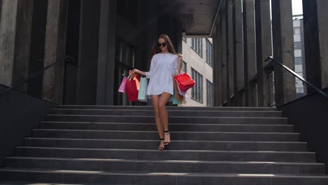 Blonde-girl-walking-from-centre-mall-with-shopping-bags.-Good-Black-Friday-holiday-sale-purchase