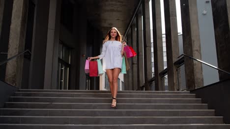 Attractive-girl-walking-from-centre-mall-with-shopping-bags,-happy-with-purchase-on-Black-Friday