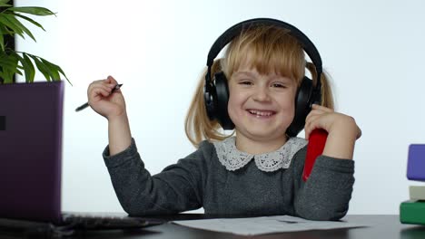 Child-schoolgirl-laughing-and-smiling.-Learning-lessons-at-home-and-using-digital-smartphone