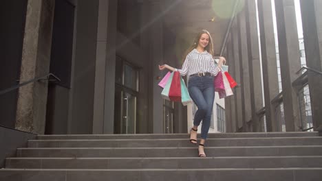 Smiling-girl-walking-from-centre-mall-with-shopping-bags,-happy-with-purchase-on-Black-Friday
