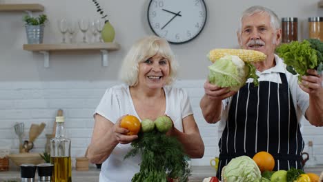 Ältere-Männer-Und-Frauen-Empfehlen-Den-Verzehr-Von-Rohem-Gemüse.-Reifes-Großelternpaar-In-Der-Küche