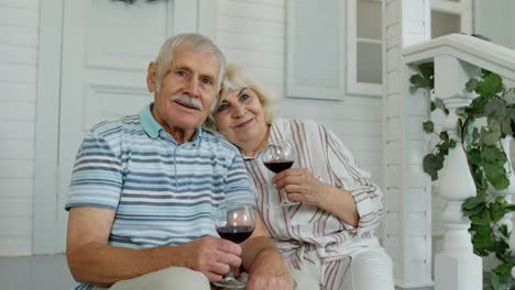 Älteres-Paar-Trinkt-Wein-Und-Umarmt-Sich-Während-Der-Coronavirus-Quarantäne-Zu-Hause-Auf-Der-Veranda