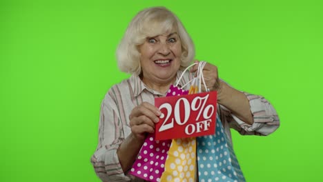 Grandmother-showing-20-percent-Off-inscription-sign-and-shopping-bags.-Shopping-on-Black-Friday