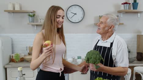 Senior-grandfather-with-granddaughter-recommending-eating-raw-vegetable-food.-Vegetable-diet