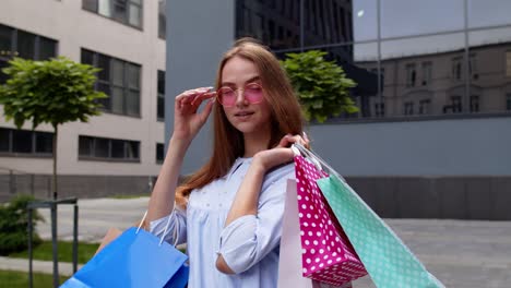 Girl-holding-colorful-shopping-bags,-rejoicing-discounts-in-fashion-store,-enjoying-shopping-in-mall