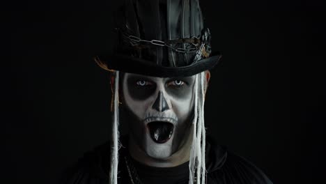 Man-in-skeleton-Halloween-costume-opening-his-mouth,-showing-black-tongue,-dirty-teeth,-scaring-you