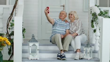 Älteres-Kaukasisches-Paar-Nutzt-Mobiltelefon-Für-Videoanrufe-Und-Macht-Selfie-Auf-Der-Veranda-Zu-Hause