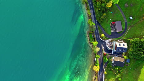 overhead-view-from-drone-tracking-along-a-lakeside-road-in-Austria